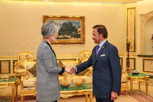 This photo provided by the South Korean Ministry of Foreign Affairs shows Foreign Minister Kang Kyung-wha (L) and Brunei's Sultan Hassanal Bolkiah shaking hands during their meeting in Bandar Seri Begawan, Brunei, on Jan. 12, 2019. (Yonhap)