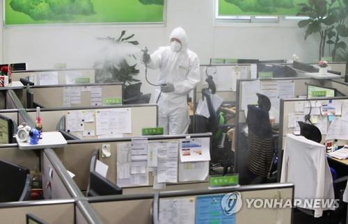 A health worker sterilizes a call center run by the Gyeonggi Province government in Suwon, south of Seoul, on March 11, 2020, after nearly 100 people linked to a call center in Seoul were diagnosed with the new coronavirus. (Yonhap)