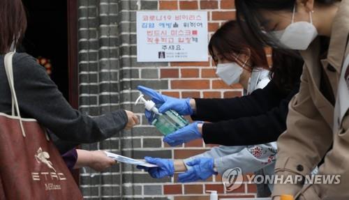 This photo, taken on May 24, 2020, shows Catholics using hand sanitizers before attending Mass at Myeongdong Cathedral in Seoul. (Yonhap)
