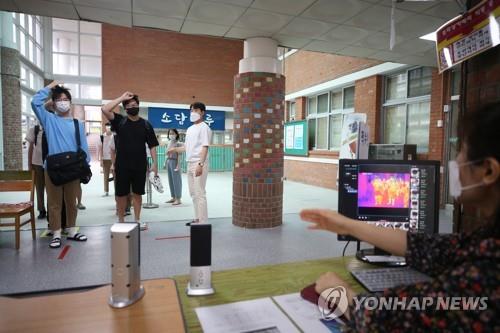High school pupils have their body temperatures checked before heading into classrooms in Gwangju, 329 km south of Seoul, on June 3, 2020. (Yonhap)