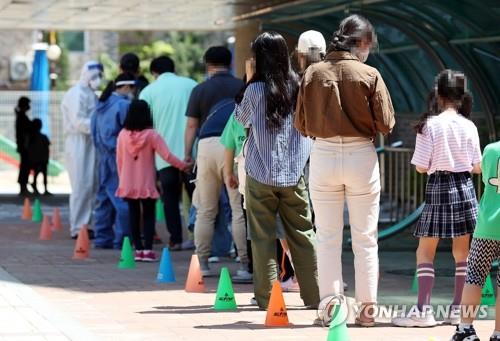 Students and their parents wait in line to take COVID-19 tests at an outdoor clinic temporarily set up at an elementary school in Incheon, west of Seoul, on May 29, 2020, as new infections broke out in the city. (Yonhap)