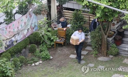 This file photo, from May 21, 2020, shows prosecutors carrying out evidence from a shelter in Mapo, western Seoul, run by the KCJR, as part of an investigation over allegations that former chief of the group, Rep. Yoon Mee-hyang, misused donations and exploited the victims for her political ambitions. (Yonhap)