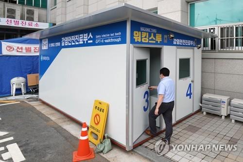 This photo provided by Dongdaemun Ward Office shows a person walking into a walk-thru clinic in Seoul on July 7, 2020, to be tested for the coronavirus. (Yonhap)