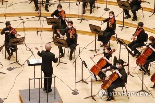 This file photo from June 5, 2020, shows a rehearsal of the Seoul Philharmonic Orchestra with members seated far apart and wearing masks at the Lotte Concert Hall in southeastern Seoul. (Yonhap) 