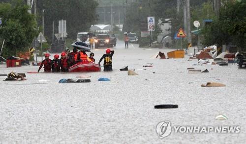 Residents of a village in Cheorwon, Gangwon Province, evacuate a flooded area in a boat on Aug. 5, 2020. (Yonhap)