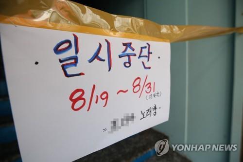 A sign in front of a karaoke center in South Korea says business is suspended till the end of August (Yonhap)