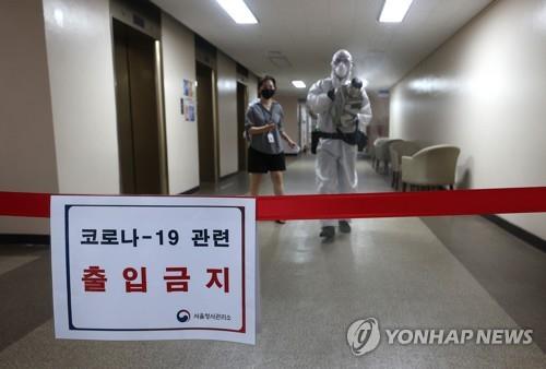 A quarantine worker disinfects the main building of the central government complex in central Seoul on Aug. 26, 2020, after a confirmed COVID-19 case was reported there. (Yonhap)
