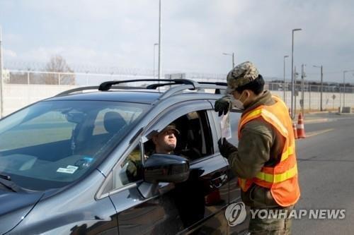 A U.S. Forces Korea (USFK) member explains anti-coronavirus guidelines to a driver in front of Camp Humphreys in Pyeongtaek, Gyeonggi Province, on April 5, 2020, in this photo provided by USFK. (PHOTO NOT FOR SALE) (Yonhap)