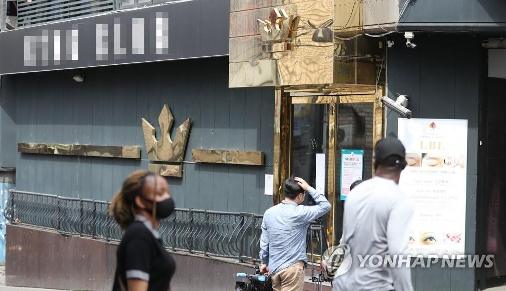 In the file photo taken May 7, 2020, people pass by a dance club in the popular international district of Itaewon in Seoul. (Yonhap)