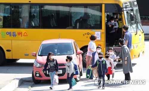 This undated file photo shows children getting off a school bus. (Yonhap) 