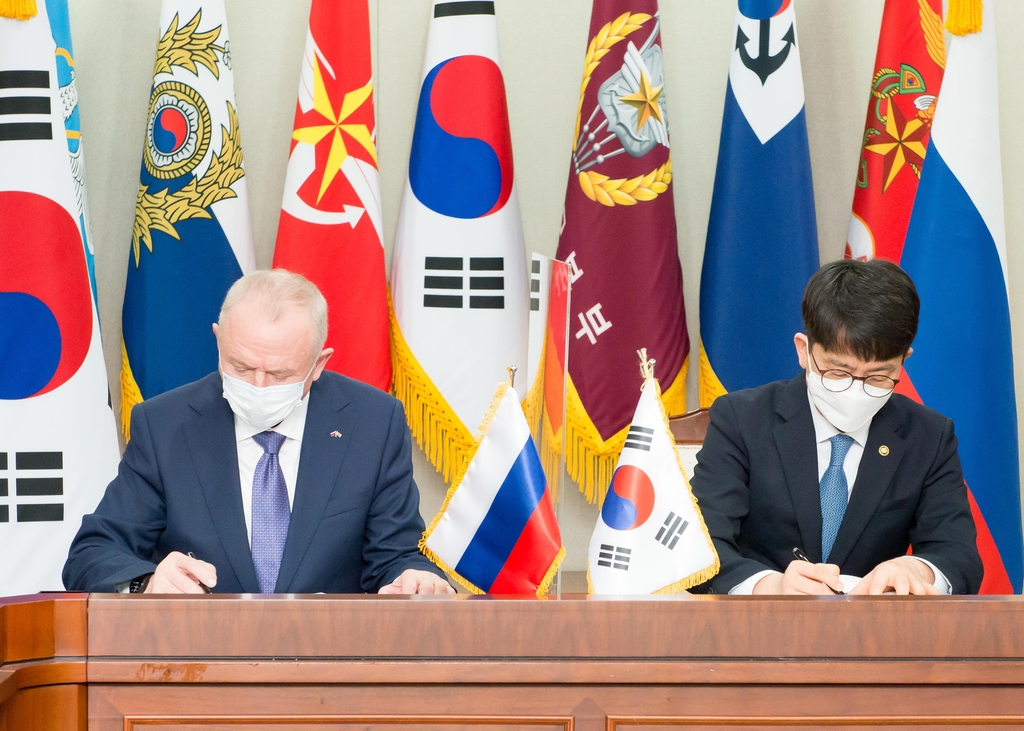 Vice Defense Minister Park Jae-min (R) and his Russian counterpart Alexander Fomin sign an agreement to boost the two countries' defense cooperation at the defense ministry headquarters in Seoul on March 29, 2021, in this photo provided by the ministry. (PHOTO NOT FOR SALE) (Yonhap)