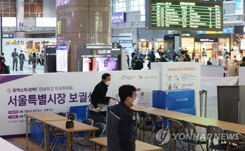 Officials erect a polling station for early voting at the Yongsan rail station in central Seoul on March 31, 2021, ahead of the April 7 by-elections. (Yonhap)