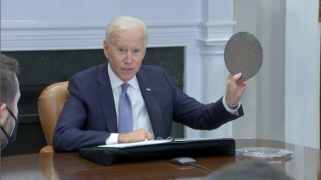 The captured image from a White House Youtube channel shows President Joe Biden holding up a wafer of semiconductor while speaking in a virtual meeting with 19 global companies at the White House in Washington on April 12, 2021 to discuss ways to address a semiconductor shortage in the United States. (PHOTO NOT FOR SALE) (Yonhap)