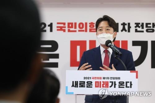 Lee Jun-seok (L) delivers an acceptance speech after winning the leadership election of the People Power Party on June 11, 2021 to become the party's youngest chief. (Yonhap)