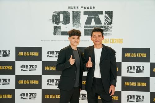 This photo provided by NEW shows actor Hwang Jung-min (R) and director Pil Kam-sung posing during a press conference streamed online on July 15, 2021. (PHOTO NOT FOR SALE) (Yonhap)