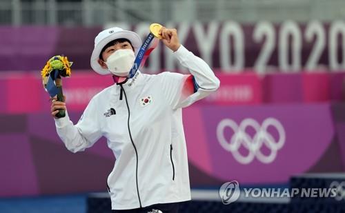 South Korean archer An San shows off her gold medal on the podium during the awards ceremony of the women's individual event at the Tokyo Olympics at Yumenoshima Final Field in Tokyo on July 30, 2021. An also won gold medals in the mixed archery team and women's team events. (Yonhap)