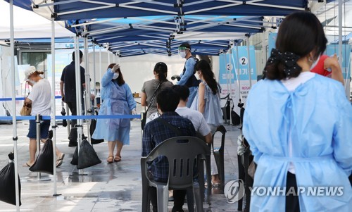 People wait to get tested for COVID-19 at a screening center in northern Seoul on Aug. 3, 2021. (Yonhap)