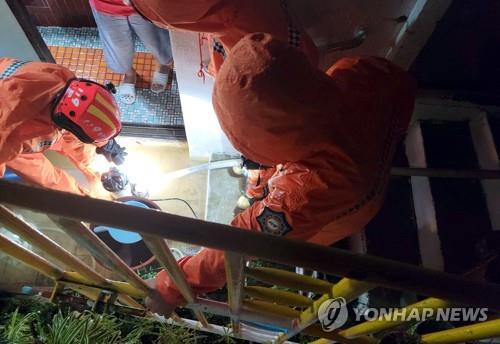 Firefighters work to remove water from a flooded home in Jeju, South Korea, on Sept. 17, 2021, in this photo provided by the Jeju Fire Safety Headquarters. (PHOTO NOT FOR SALE) (Yonhap)