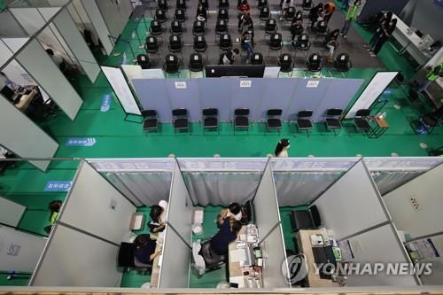 People wait to be vaccinated at an inoculation center in Seoul on Oct. 14, 2021. (Yonhap) 