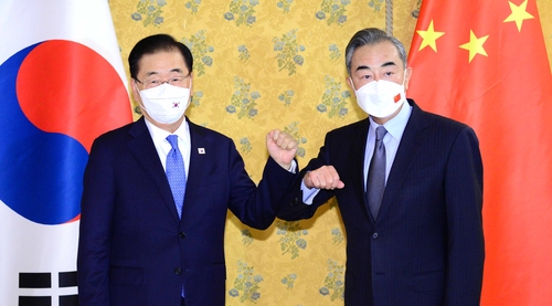 Foreign Minister Chung Eui-yong (L) and his Chinese counterpart, Wang Yi, pose for a photo during their meeting in Rome on Oct. 29, 2021 (local time), on the sidelines of the Group of 20 summit, in this photo provided by Chung's office. (PHOTO NOT FOR SALE) (Yonhap) 