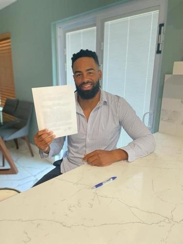 In this photo provided by the KT Wiz on Dec. 1, 2021, Henry Ramos poses with the contract he's signed with the Wiz. (PHOTO NOT FOR SALE) (Yonhap)
