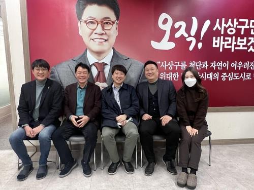 This photo, provided by an aide to People Power Party Chairman Lee Jun-seok, shows Lee (C) with staff members at a local party office in Busan on Dec. 1, 2021. (Yonhap)