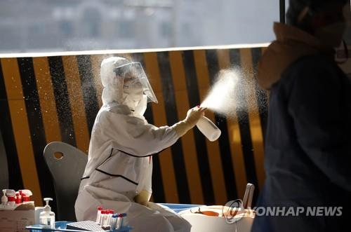 A health worker sprays disinfectant at a makeshift testing station in the southwestern city of Gwangju on Jan. 7, 2022, in this photo provided by a local government. (PHOTO NOT FOR SALE) (Yonhap)