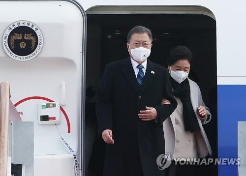 President Moon Jae-in (L) and first lady Kim Jung-sook arrive at Seoul Air Base in Seongnam, just south of Seoul, on Jan. 22, 2022, after a three-nation trip to the Middle East. (Yonhap)