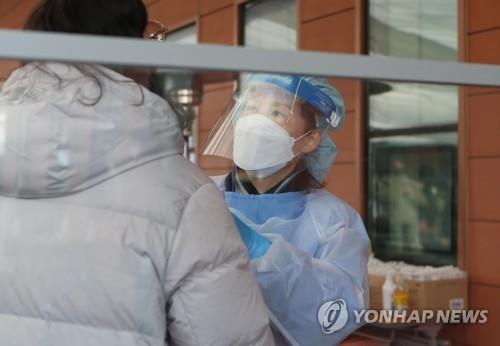 A health worker conducts a coronavirus test in the southern city of Changwon, South Gyeongsang Province, on Feb. 2, 2022. (Yonhap)