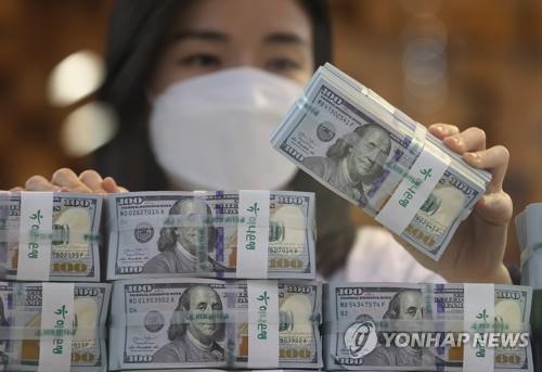 A clerk sorts US$100 banknotes at the headquarters of Hana Bank in Seoul on Dec. 3, 2021. (Yonhap)
