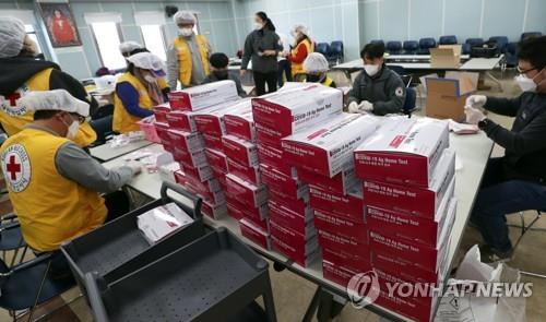 Officials package COVID-19 self-test kits at a Red Cross office in the southwestern city of Jeonju on Feb. 23, 2022, to distribute them for free to kindergartens and elementary schools in their jurisdiction ahead of the start of the spring semester. (Yonhap)