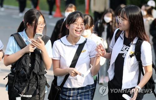 Students talk to each other without wearing face masks on their way to school in the southwestern city of Gwangju on May 2, 2022, as South Korea lifted the outdoor mask mandate starting the same day in a move to regain normalcy. 
