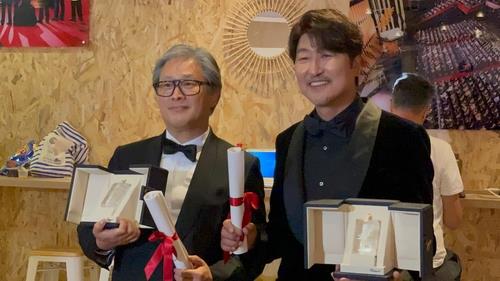 Director Park Chan-wook (L) of "Decision to Leave" and actor Song Kang-ho of "Broker" pose for photos after winning Best Director and Best Actor, respectively, at the 75th Cannes Film Festival in Cannes, France, on May 28, 2022. (Yonhap)