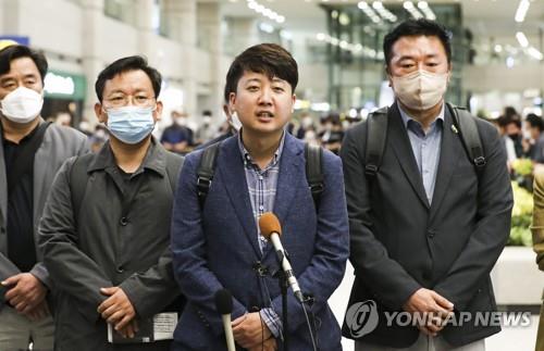 Ruling People Power Party Chairman Lee Jun-seok (2nd from L) speaks to reporters at Incheon International Airport, west of Seoul, on June 9, 2022, after returning from a trip to Ukraine. (Pool photo) (Yonhap)