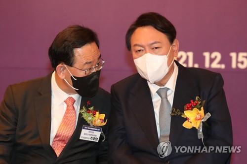 This file photo taken Dec. 15, 2021, shows Rep. Joo Ho-young (L) of the People Power Party (PPP) speaking with then PPP presidential candidate Yoon Suk-yeol at a forum in Seoul. (Pool photo) (Yonhap)
