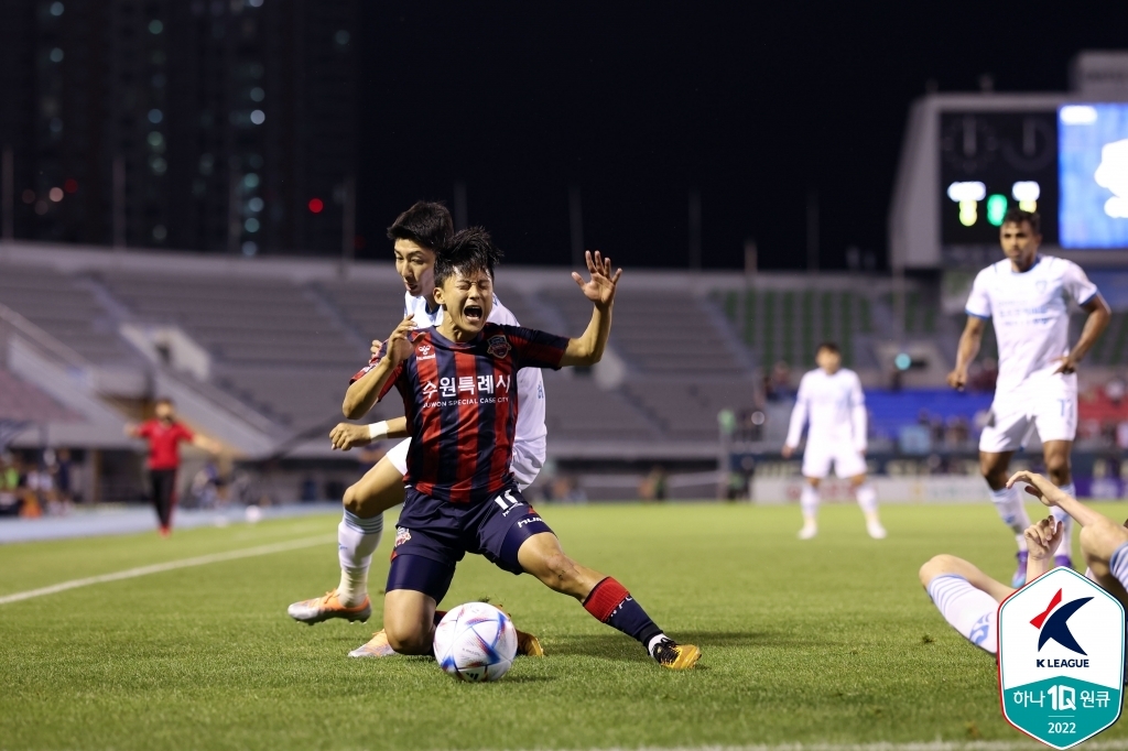 Lee Seung-woo of Suwon FC (front) is challenged by Heo Yong-jun of Pohang Steelers during the clubs' K League 1 match at Suwon Stadium in Suwon, 35 kilometers south of Seoul, on June 21, 2022, in this photo provided by the Korea Professional Football League. (PHOTO NOT FOR SALE) (Yonhap)