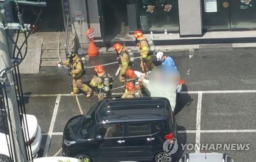 This photo provided by a reader shows rescue workers carrying away a victim from a hospital where a fire killed five people on Aug. 5, 2022. (PHOTO NOT FOR SALE) (Yonhap)