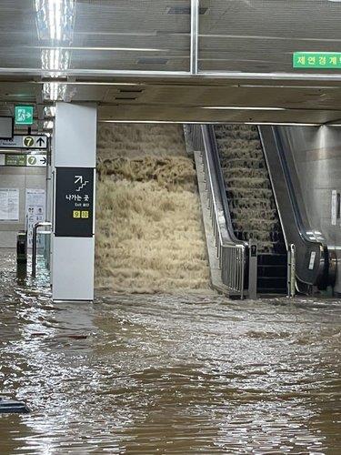 Flooding waters rush into Isu Station in Seoul on Aug. 8, 2022. (Yonhap)