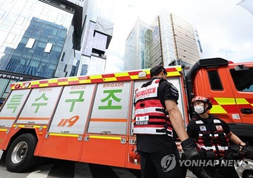 Rescue officials conduct a search operation on Aug. 10, 2022, to find two people who disappeared into a manhole in southern Seoul. (Yonhap)