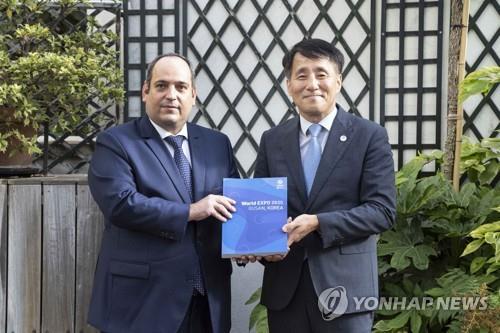 This photo, provided by South Korea's industry ministry, shows First Vice Industry Minister Jang Young-jin (R) and Dimitri Kerkentzes, secretary general of the Bureau International des Expositions (BIE), posing for a photo in Paris on Sept. 7, 2022, after Jang submitted the official application to host the 2030 World Expo in the southern city of Busan. (PHOTO NOT FOR SALE) (Yonhap)
