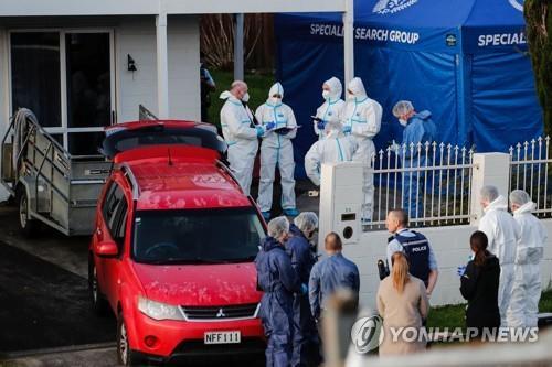 This file photo from the Associated Press shows New Zealand police investigating the scene where two children's bodies were found in suitcases in Auckland, New Zealand, on Aug. 11, 2022. (PHOTO NOT FOR SALE) (Yonhap)