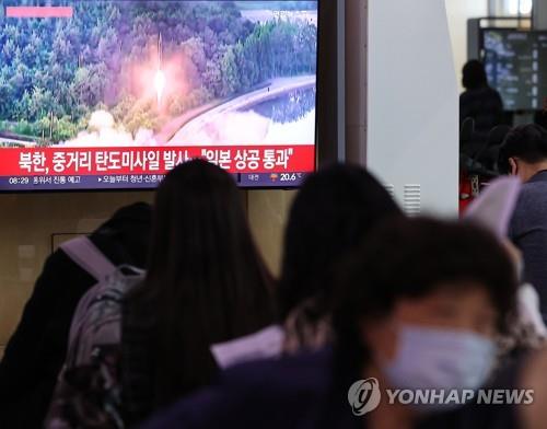 Citizens watch the news at Seoul Station in central Seoul on Oct. 4, 2022, when North Korea fired an intermediate-range ballistic missile over Japan. (Yonhap)