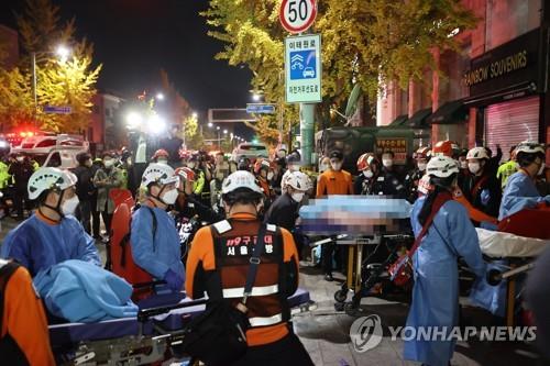 Rescuers move patients on Oct. 30, 2022, in Seoul's Itaewon district after a stampede during Halloween parties killed at least 149 people, mostly teenagers and young adults in their 20s, and injured 76 others. (Yonhap)