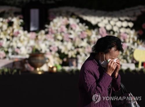 A woman dries her tears on Nov. 4, 2022, after paying tribute at a mourning altar for victims killed in the deadly Itaewon crowd crush, set up at Seoul Plaza. (Yonhap) 