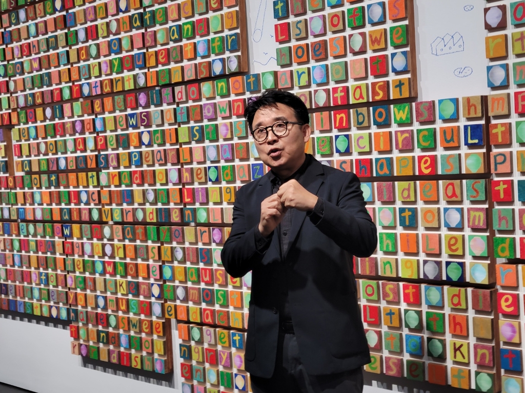 Multimedia artist Kang Ik-joong explains his artwork displayed at his solo exhibition "The Moon is Rising" held at Gallery Hyundai in Seoul on Nov. 4, 2022. (Yonhap)