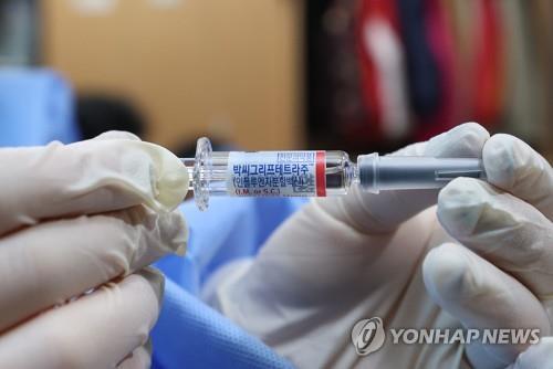 A medical worker holds up a vial of a vaccine at a public facility in Seoul, in this file photo taken Oct. 18, 2022. (Yonhap)