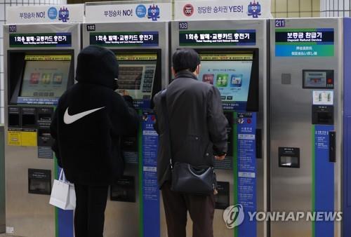 This file photo shows people buying subway tickets at a Seoul station. (Yonhap)