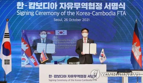 This file photo, provided by the trade ministry, shows then-South Korean Trade Minister Yeo Han-koo (R) and a Cambodian official taking part in a signing ceremony of their free trade agreement on Oct. 26, 2021. (PHOTO NOT FOR SALE) (Yonhap)