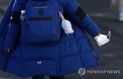 A student in the southeastern city of Busan holds a mask on Jan. 25, 2023. (Yonhap) 