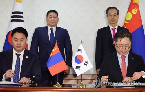South Korea's Second Vice Industry Minister Park Il-jun (R) and his Mongolian counterpart, Ganbaatar Jambal (L), sign a memorandum of understanding on cooperation of rare metals in Seoul on Feb. 15, 2023, with South Korean Prime Minister Han Duck-soo (2nd from R) and his Mongolian counterpart, Luvsannamsrai Oyun-Erdene, attending the signing ceremony. (Yonhap)